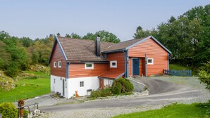 A two-story house with a red and white exterior, a chimney, and a blue door. - Rødehuset by Interhome (Reksteren)