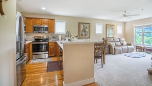 A spacious kitchen with wooden cabinets, stainless steel appliances, and a central island. - Evergreens 1421- Mtn Condo, Gated Resort, Indoor/Outdoor Pools & Hot Tub (Boone)