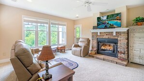 A living room with a fireplace, comfortable seating, and a television. - Evergreens 1421- Mtn Condo, Gated Resort, Indoor/Outdoor Pools & Hot Tub (Boone)
