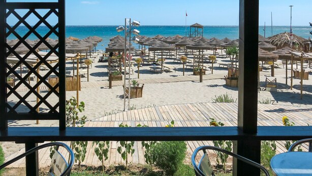 A beach view from a covered area with umbrellas and lounge chairs. - Su Tramatzu (PCR105) by Interhome (Porto Corallo)