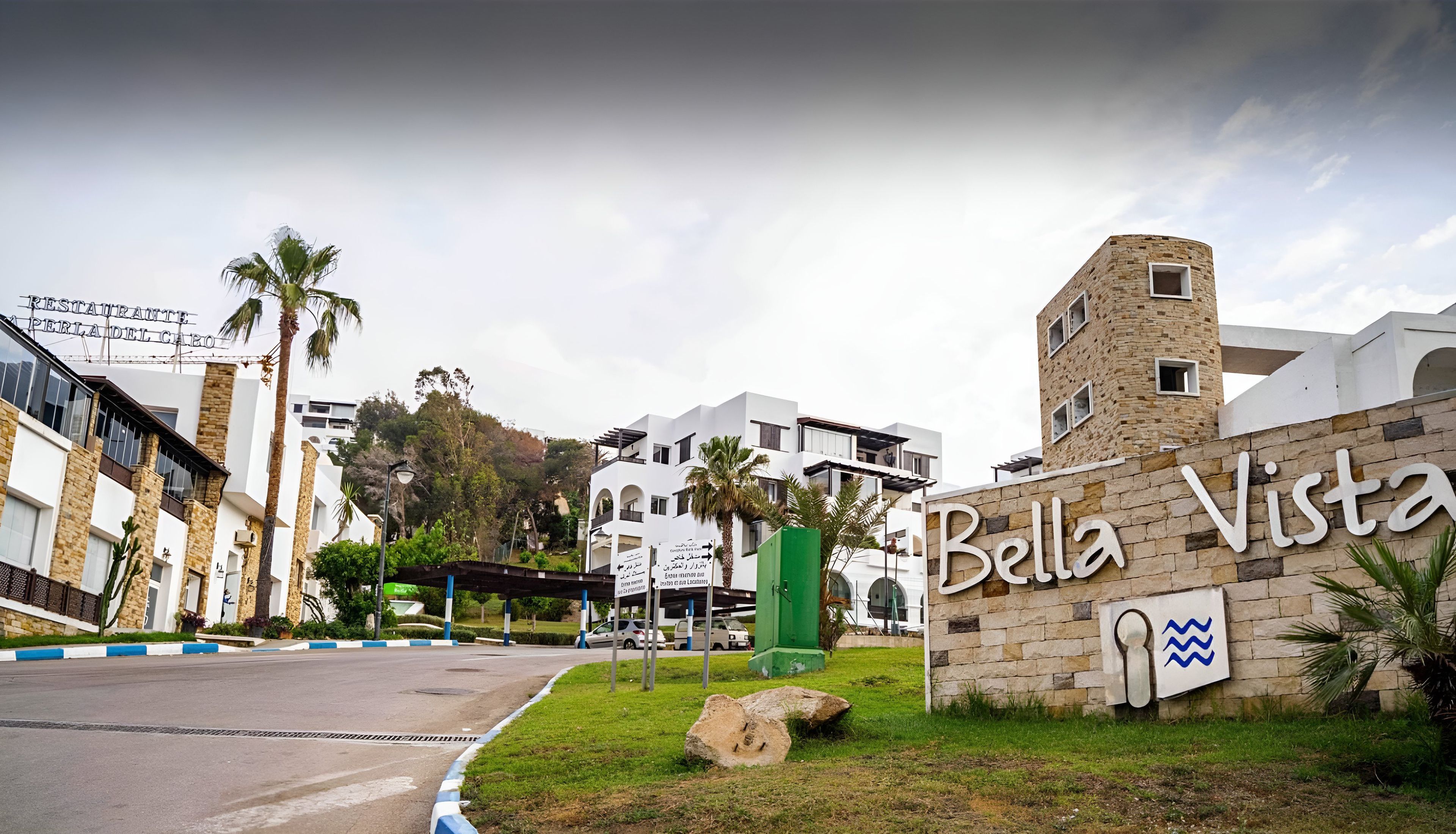Un bâtiment sur lequel on peut lire l’inscription « Bella Vista », et au fond, un restaurant appelé « RESTAURANT PERLA DEL CABO ».