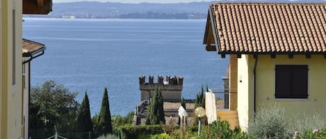 A coastal view with a building featuring a tiled roof and a small window.