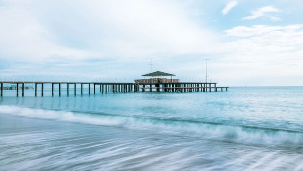 A pier extending into calm waters with a covered structure at the end. - Casa Maja by Interhome (Roccascalegna)