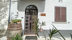A white building with a wooden door, a balcony, and a window with shutters. - Casa Maja by Interhome (Roccascalegna)