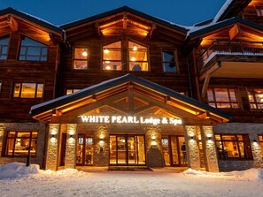 Una cabaña de madera con un letrero que dice 'WHITE PEARL Lodge & Spa'.