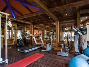 A gym with treadmills, elliptical machines, and exercise balls.