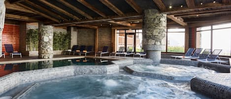 Un espace de détente avec un jacuzzi, des chaises longues et un pilier en pierre.