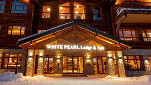 A wooden lodge with a stone facade and a sign reading "WHITE PEARL Lodge & Spa". - CGH Rés&Spa White Pearl 5* by Interhome (La Plagne)