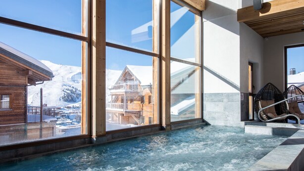 A spa area with a hot tub and large windows overlooking a snowy mountain landscape. - CGH Rés&Spa White Pearl 5* by Interhome (La Plagne)