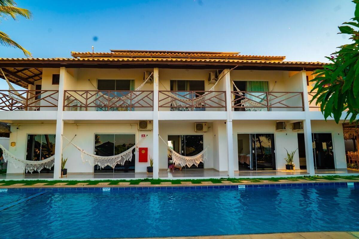 Un hotel de dos pisos con piscina delantera.