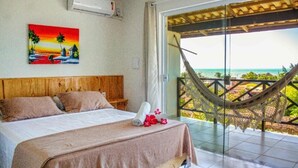 A bedroom with a bed, a painting, and a hammock. - Milano Hotel Pousada Canoa Quebrada (Aracati)