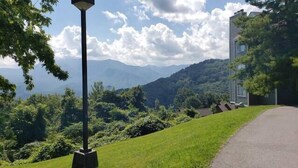 Ein Weg, der zu einem Gebäude mit Blick auf Berge und Grün führt.