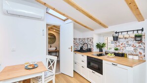 A modern kitchen with white cabinets, a wooden countertop, and a skylight. - Hedera Estate, Hedera Studio 7 (Dubrovnik)