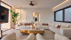 A modern living room with a sectional sofa, a wooden coffee table, and a large window. - Gavras Exclusive Villa II, Pool & Heated Whirlpool, SeaViews (9HFX+3FH Arkadi, Greece)