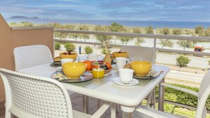 A balcony with a table set for breakfast, overlooking a coastal landscape. - Port Pals Sea View by Interhome (Pals)