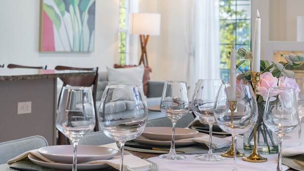 A dining area with a table set for six, featuring clear glassware and plates, a candle centerpiece, and a modern pendant light. - 3 BED/2 BATH<br>Free parking space<br>Near Rutgers University, Newark Penn Station, EWR airport, Prudential Center, MetLife Stadium, and more.<br>Fully equipped kitchen<br>Professionally styled (Newark)
