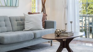 A modern living room with a grey sofa, a round coffee table, and a floor lamp. - 3 BED/2 BATH<br>Free parking space<br>Near Rutgers University, Newark Penn Station, EWR airport, Prudential Center, MetLife Stadium, and more.<br>Fully equipped kitchen<br>Professionally styled (Newark)