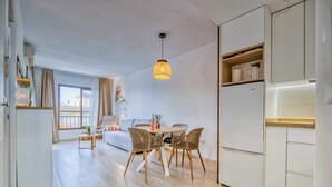 Un appartement moderne comprenant un coin repas, une cuisine et un salon.