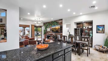 Una cocina amplia con una isla grande, muebles oscuros y una lámpara de techo moderna.