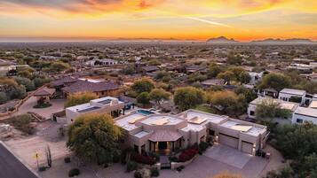 Vista aérea de una zona residencial con casas, una piscina y un edificio grande con techo plano.