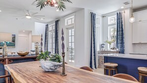 A spacious kitchen with a wooden dining table, bar stools, and a large island.