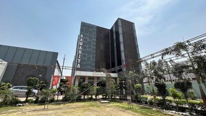 A modern building with the sign "SAWARIYA" on its facade, surrounded by a landscaped garden with palm trees and a clear sky. - Sawariya The Boutique Resort (Mahasi)