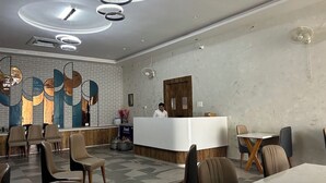 A modern hotel lobby with a reception desk, seating area, and decorative wall art. - Sawariya The Boutique Resort (Mahasi)