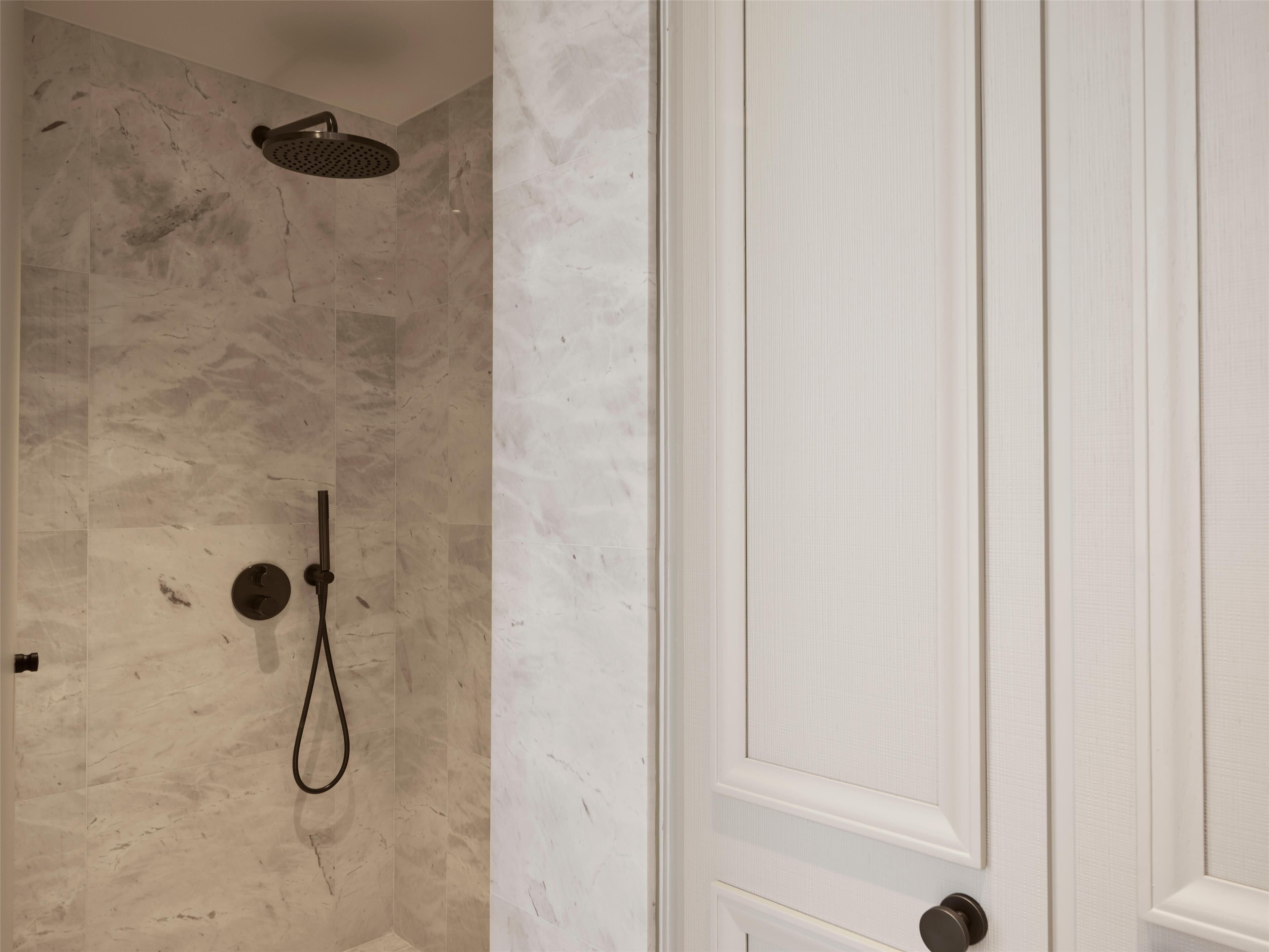 Une salle de bain avec une douche, des toilettes et une porte.