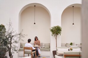 A serene outdoor seating area with a wooden table, two cushioned sofas, and a potted plant. - Amyth of Nicosia (Nicosia)