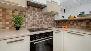 A modern kitchen with a stove, oven, and a potted plant.