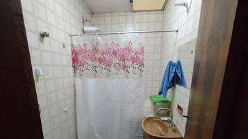 Chuveiro, toalhas de banho, sabonete, papel higiênico