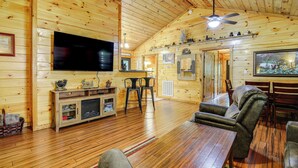 A cozy cabin interior with wooden walls, a flat-screen TV, a fireplace, and a dining area. - 2 Mi to Dtwn Gatlinburg: 'crescent Claw Cabin!' (Gatlinburg)