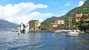 A waterfront with buildings, a dock, and boats. - Glicine by Interhome (Varenna)