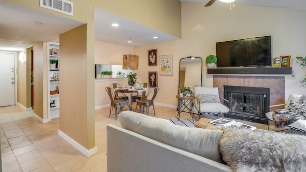 A modern living room with a fireplace, a dining area, and a ceiling fan. - College Station Gem w/ Pool Access Near University (College Station)