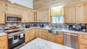 Una cucina moderna con mobili in legno, elettrodomestici in acciaio inossidabile e paraschizzi piastrellato.