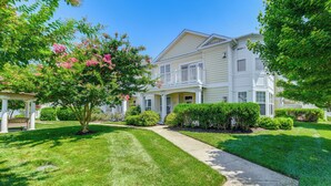 A two-story house with a front porch, a covered patio, and a well-maintained lawn. - Pet-friendly Ocean View Condo w/ Community Perks! (Ocean View)