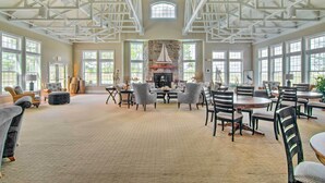 A spacious room with a high ceiling, large windows, a fireplace, and multiple seating arrangements. - Pet-friendly Ocean View Condo w/ Community Perks! (Ocean View)