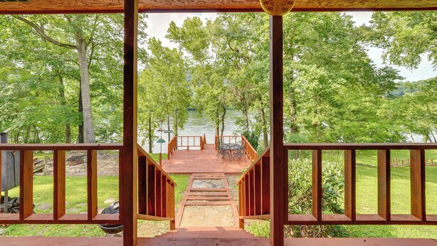 A wooden deck with a view of a lake and trees. - Flippin Home w/ Fire Pit: Walk to White River! (Flippin)