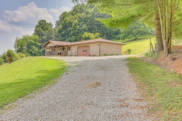 A two-story building with a gravel driveway leading to a wooden porch. - Spacious Ohio Family Home on 5-acre Property! (New Philadelphia)
