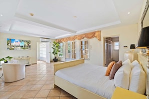 A spacious bedroom with a large bed, a desk, and a potted plant. - Resort-Style 6BR Villa w/ Pool & Sun near Beach (Noord)