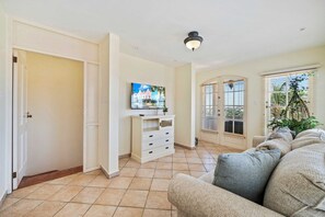 A living room with a sofa, a television, and a cabinet.
