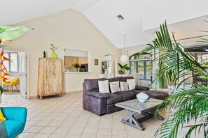 Una sala de estar con sofá, mesa de centro y vistas al exterior.