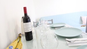 Un tavolo da pranzo con una bottiglia di vino, bicchieri, piatti e una banana.