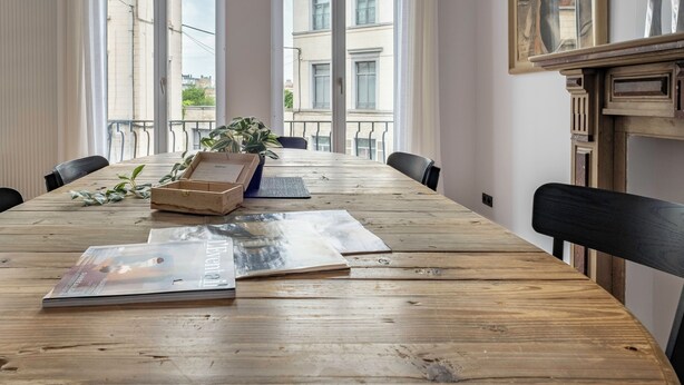 A conference room with a long wooden table, chairs, a potted plant, and a painting on the wall. - Brussels Toison D'or (Brussels)