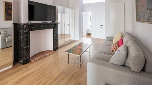 A modern living room with a fireplace, a grey sofa, and a flat-screen TV. - Brussels Toison D'or (Brussels)
