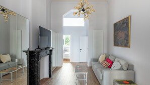 A modern living room with a fireplace, a sofa, a TV, and a painting on the wall. - Brussels Toison D'or (Brussels)
