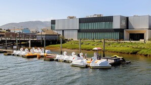 A modern building with a dock area featuring swan-shaped boats. - Sand & Sea (316) Marine Dream-Beachview with Pool (Seaside)
