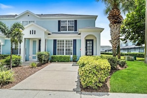 A two-story house with a front entrance, a driveway, and well-maintained landscaping.