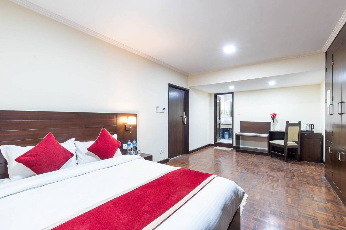 Una habitación de hotel con una cama grande, un escritorio y una silla.