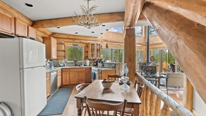 A wooden cabin interior with a kitchen, dining area, and a view of the outdoors. - NEW LISTING | 4BD Log Home in Twin Lakes, Amazing Views, Pets OK (Twin Lakes)
